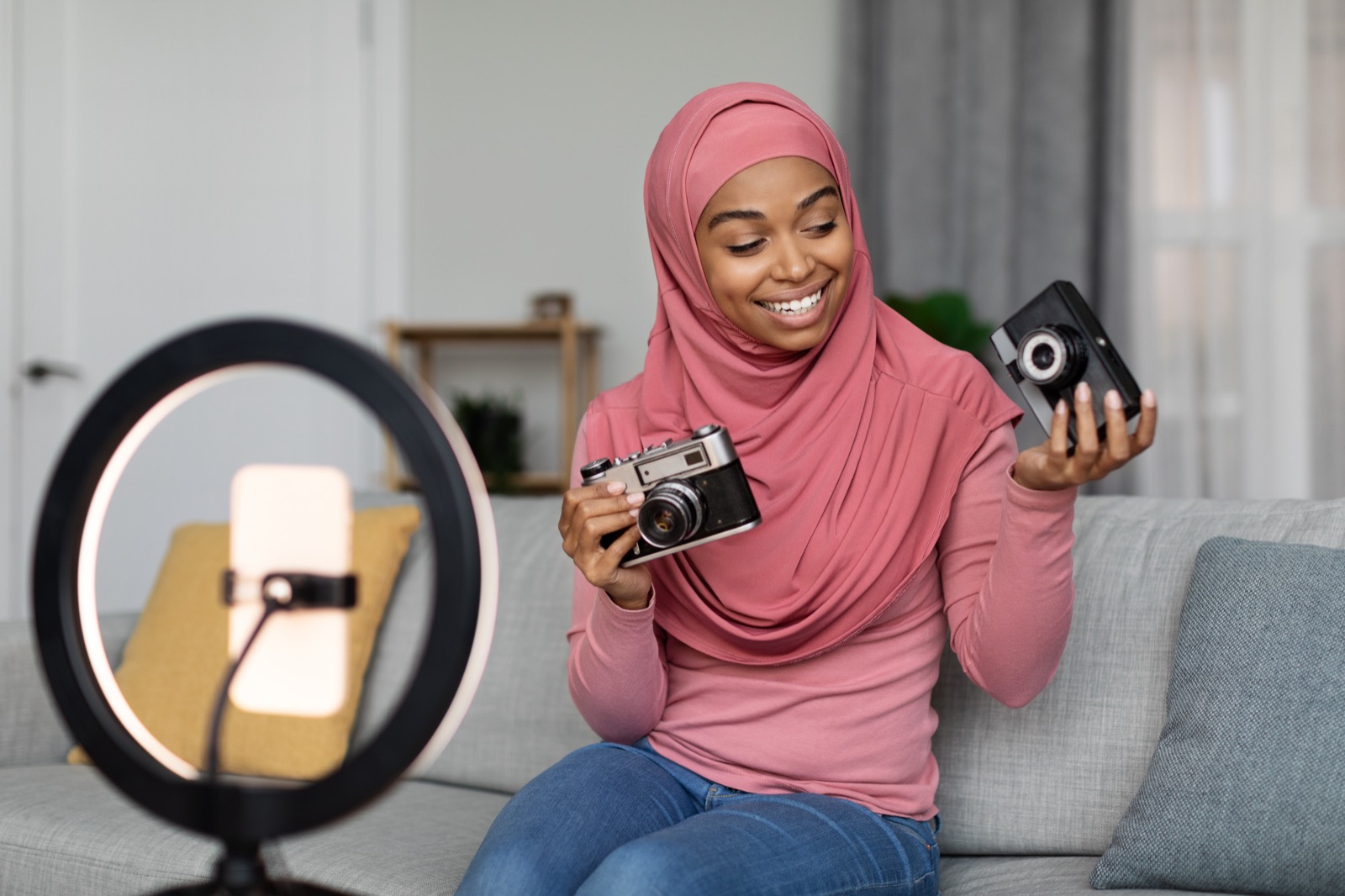 Créatrice qui présente deux produits face à son téléphone posé sur un anneau lumineux