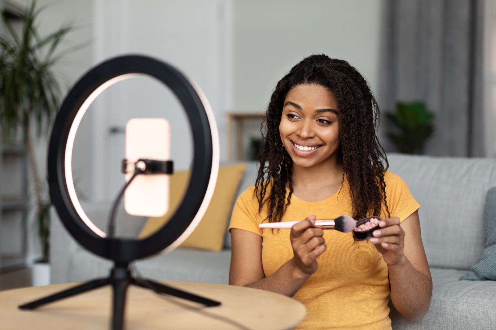 Créatrice en TikTok Live depuis son téléphone avec un ring light