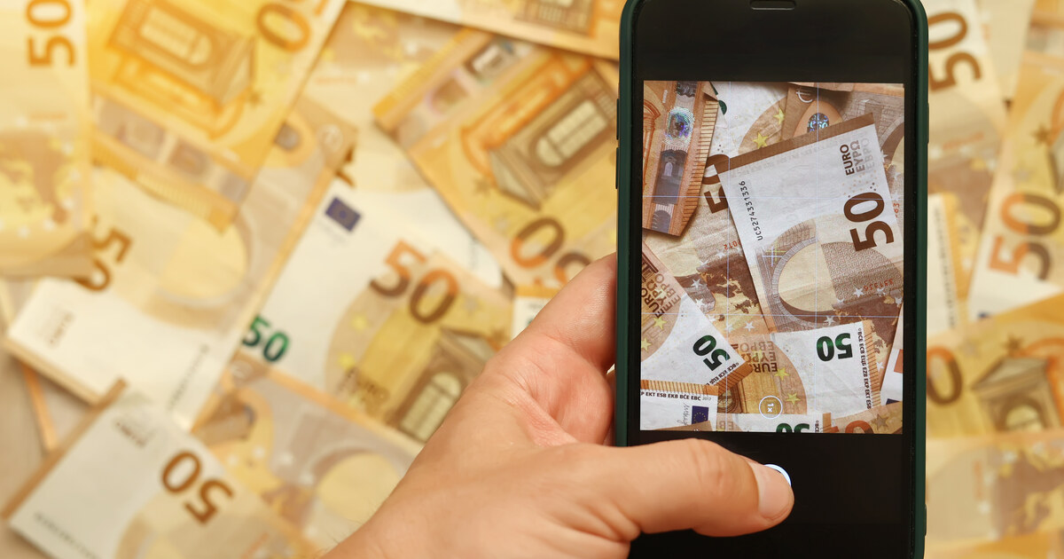 Main tenant un téléphone au-dessus de billets de 50 euros, revenus d un créateur