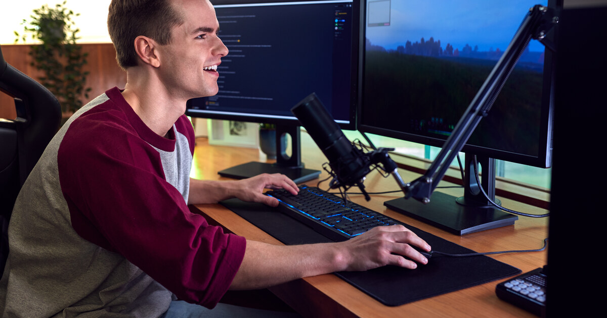 Créateur à son poste de live : double écran, micro sur bras articulé et logiciel de diffusion ouvert