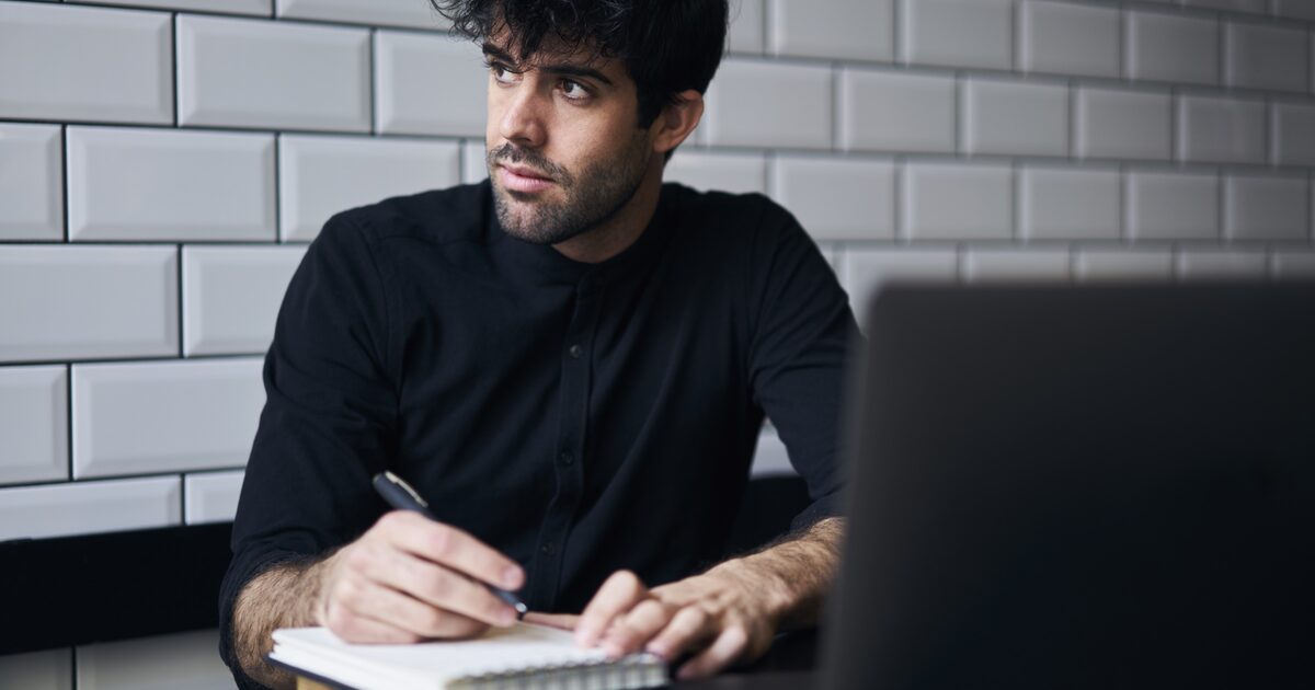Rédacteur qui écrit sa page de vente à côté de son ordinateur portable