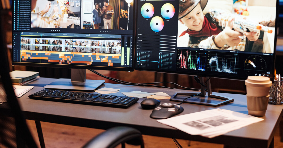 Poste de montage vidéo à double écran avec la timeline ouverte, sur un bureau clair