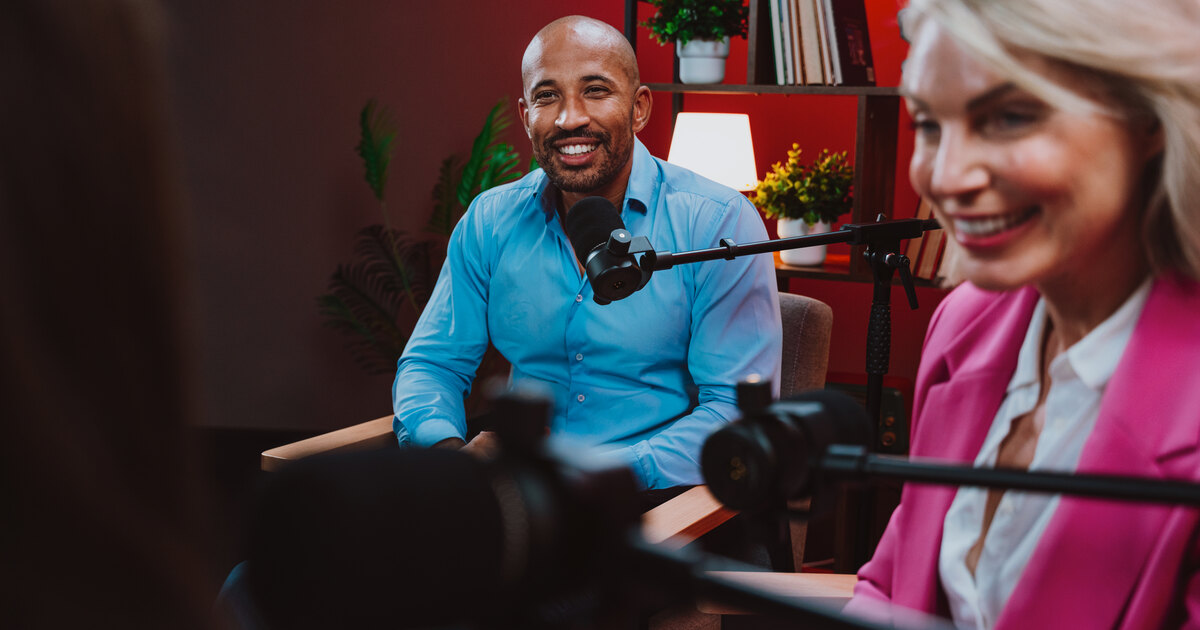 Jeune créateur noir souriant devant un micro de podcast professionnel en studio