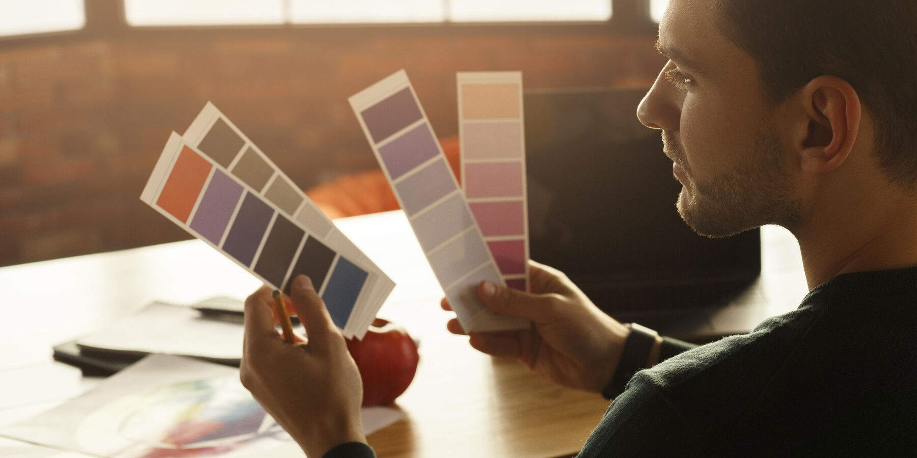 Designer qui compare des nuanciers de couleurs pour une identité visuelle