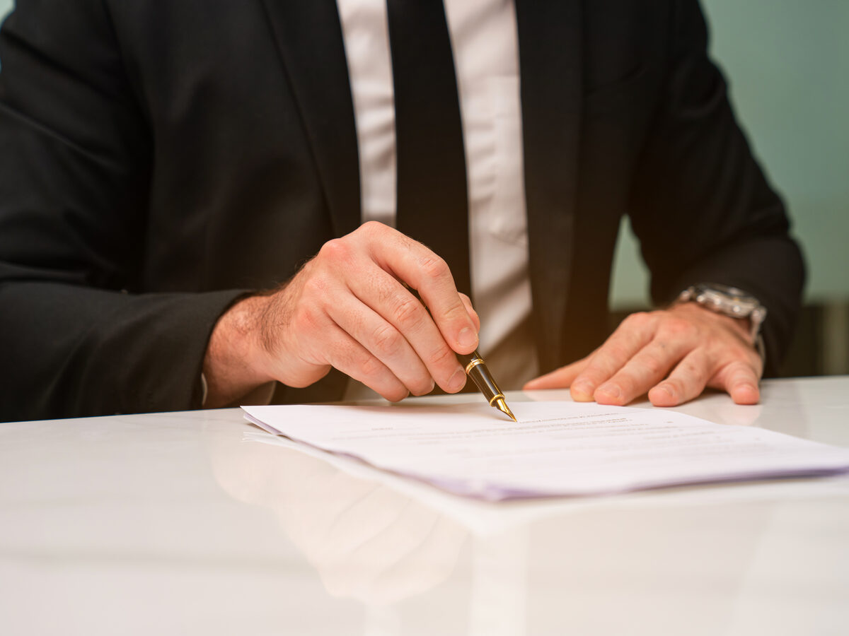 Main qui signe un contrat au stylo