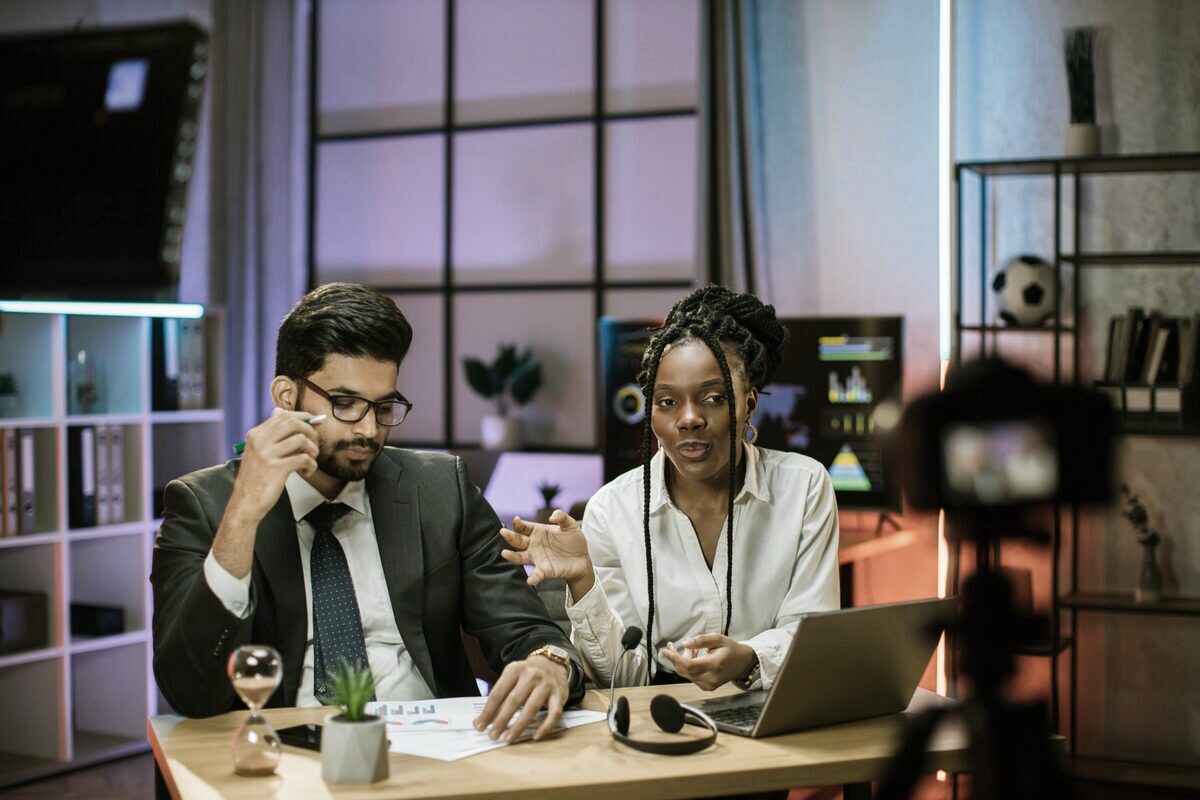 Créatrice et son interlocuteur en pleine négociation de partenariat, chiffres et documents sur la table
