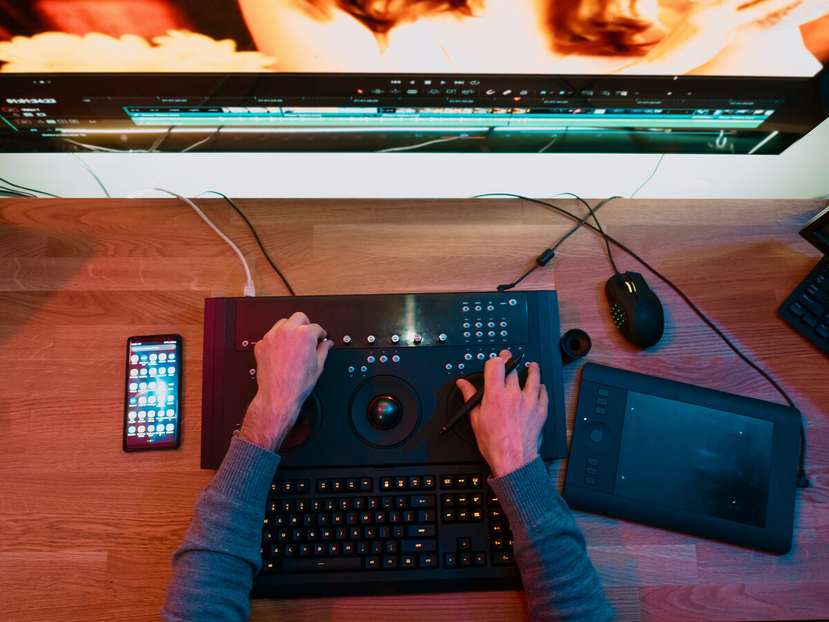 Mains sur un clavier de montage vidéo, vue de dessus