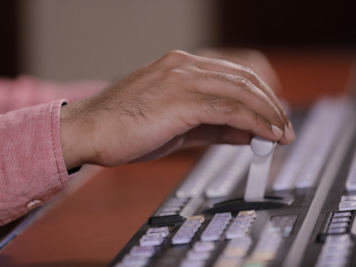 Main sur la manette d'une régie vidéo professionnelle