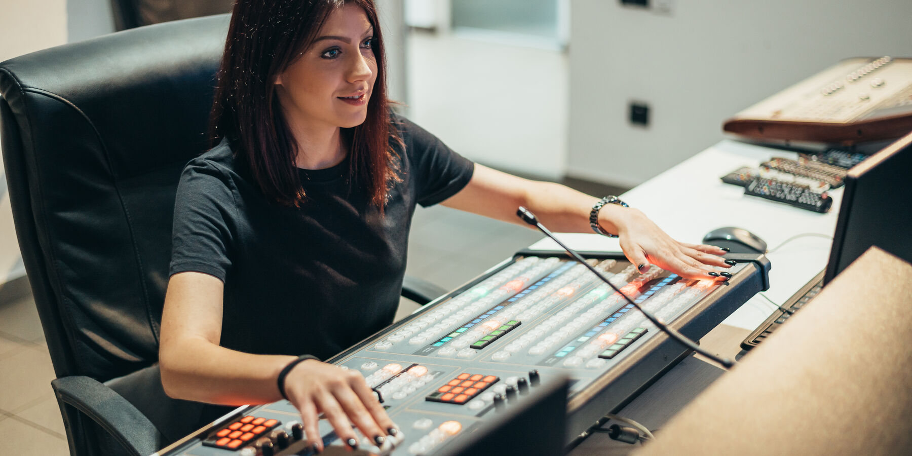Technicienne au travail sur une console de régie, en studio