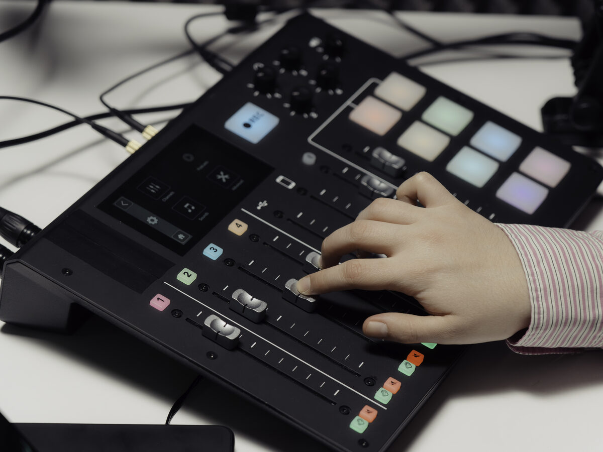 Main qui règle une table de mixage audio pendant un direct