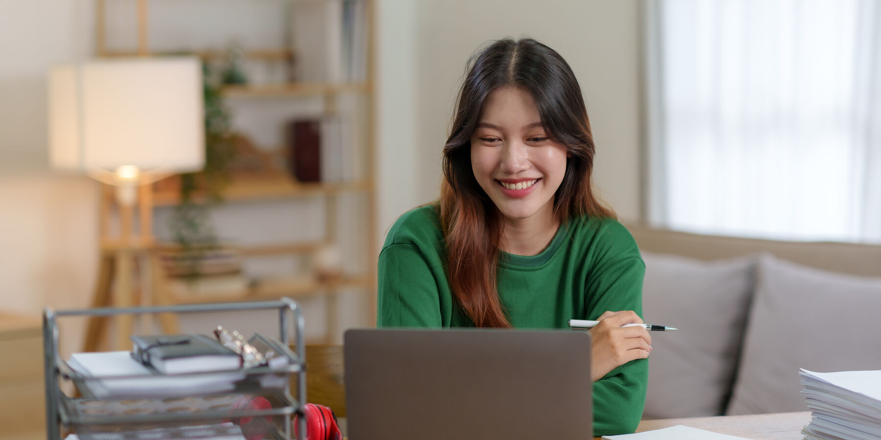 Créatrice souriante qui travaille sur son ordinateur portable