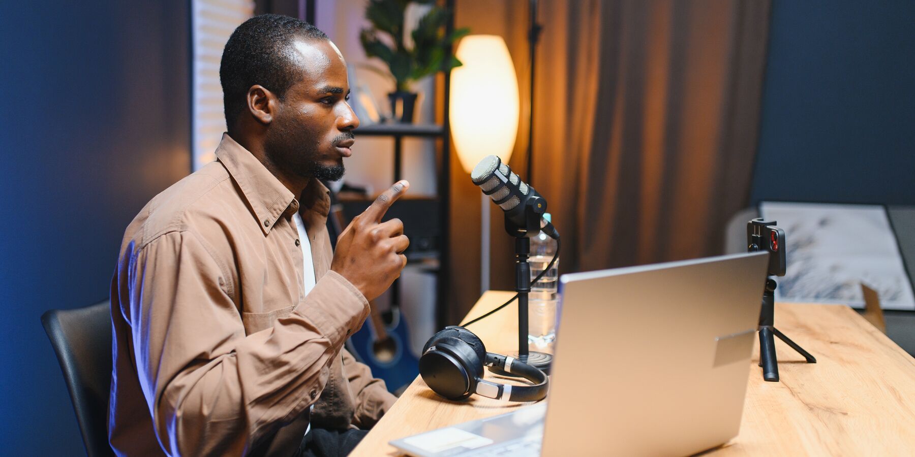 Créateur qui parle au micro devant son ordinateur, dans son studio