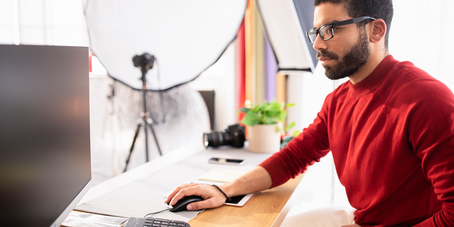 Indépendant qui prépare ses photos à son bureau, entouré de son matériel