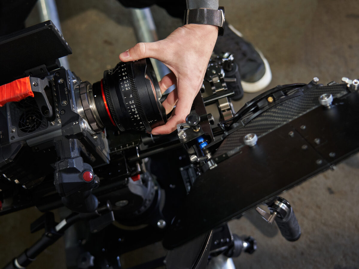 Main qui fait la mise au point sur l'objectif d'une caméra cinéma