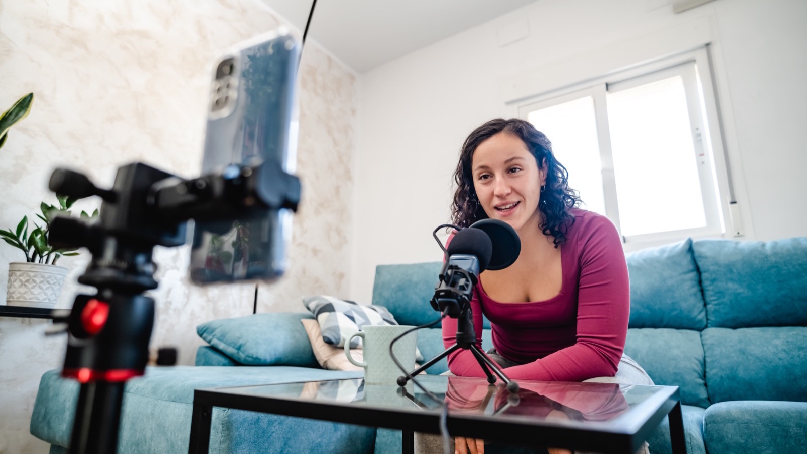 Créatrice en live depuis son salon, téléphone sur trépied en cadrage vertical et micro sur pied