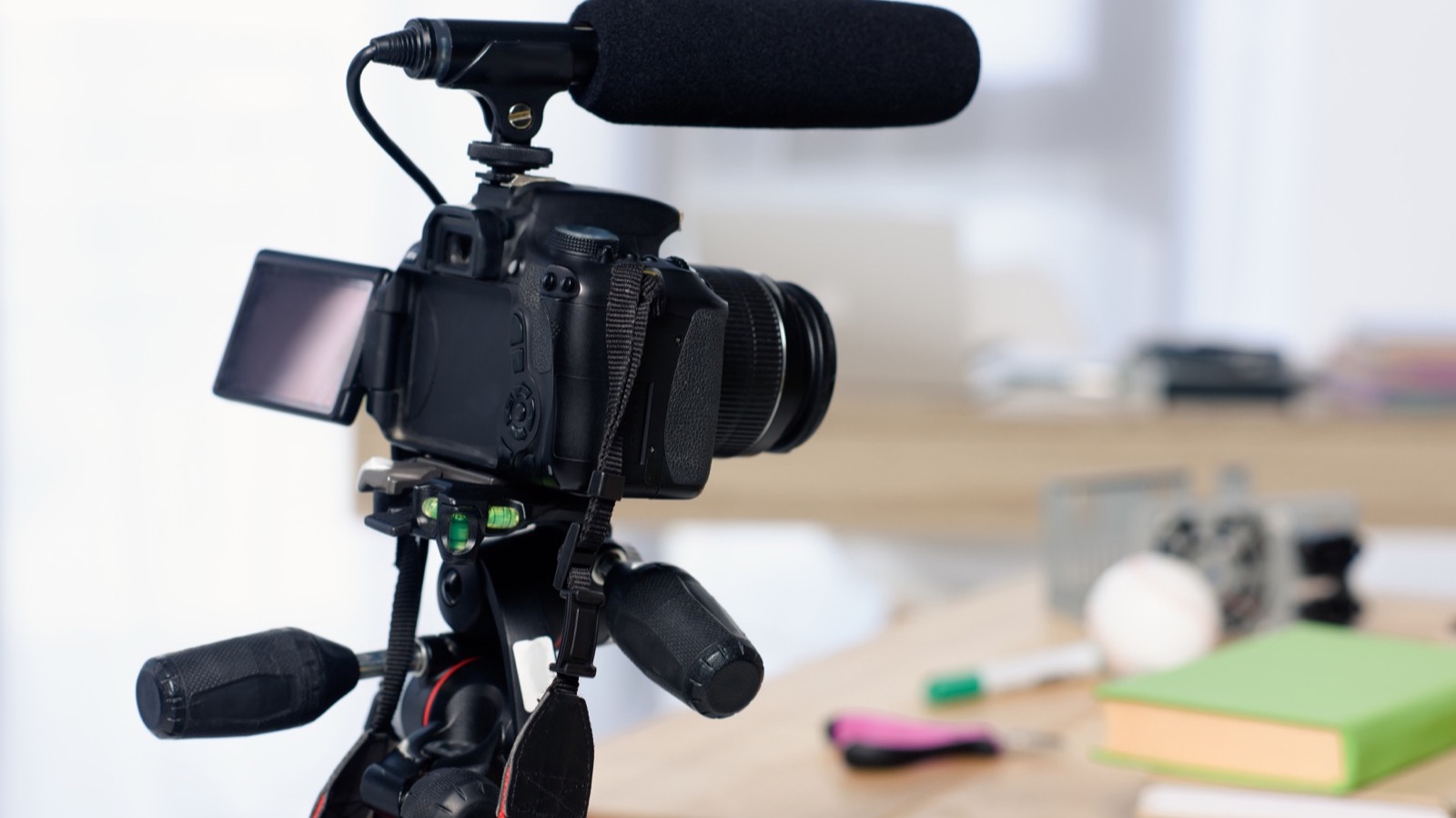 Appareil photo avec micro-canon monté sur trépied, prêt à filmer sur un bureau de créateur