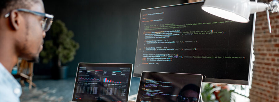 Developpeur qui code sur un setup a plusieurs ecrans